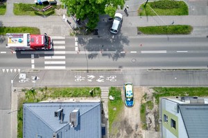 zdjęcie przedstawia policjantów wykonujących czynności na miejscu wypadku drogowego z udziałem motocykla.