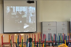 zdjęcie przedstawia policjanta w trakcie rozmowy z dziećmi