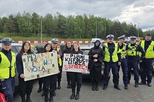 zdjęcie przedstawia policjantów i uczniów klasy mundurowej, którzy trzymają transparenty &quot;pijani kierowcy wiozą śmierć&quot;