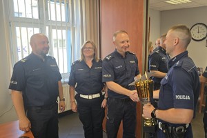 zdjęcie przedstawia kierownictwo komendy gratulujące zwycięskiemu policjantowi