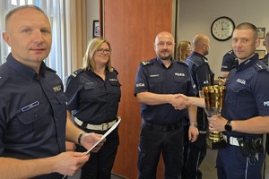 zdjęcie przedstawia kierownictwo komendy gratulujące zwycięskiemu policjantowi