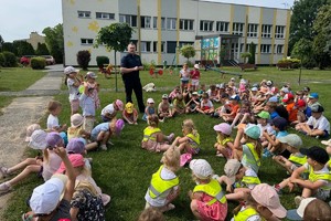 zdjęcie przedstawia policjanta z przedszkolakami