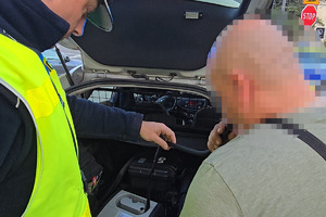 zdjęcie przedstawia policjanta badającego trzeźwość kierującego