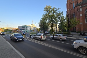 zdjęcie przedstawia policjanta kontrolującego trzeźwość kierującego