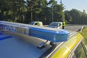 zdjęcie przedstawia policjanta kontrolującego trzeźwość kierującego