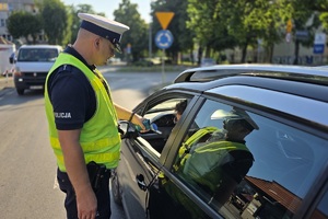 zdjęcie przedstawia policjanta kontrolującego trzeźwość kierującego
