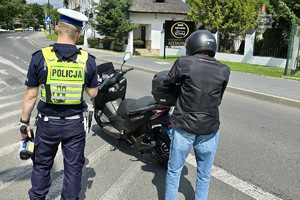 zdjęcie przedstawia policjanta w trakcie kontroli motocyklisty