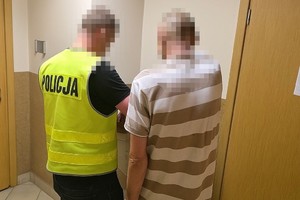 zdjęcie przedstawia moment pobierania odcisków palców od zatrzymanego