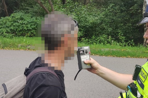 zdjęcie przedstawia rowerzystę w trakcie kontroli trzeźwości