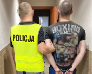 zdjęcie przedstawia mężczyznę trzymanego przez policjanta