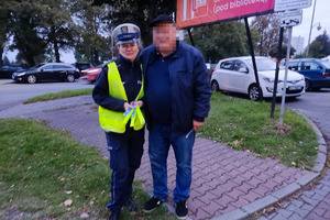 zdjęcie przedstawia policjantkę wręczającą odblaski