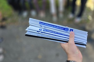 zdjęcie przedstawia policjantkę wręczającą odblaski