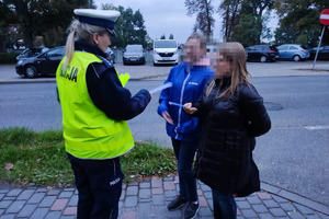 zdjęcie przedstawia policjantkę wręczającą odblaski