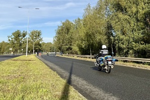 zdjęcie przedstawia policjanta zabezpieczającego trasę maratonu