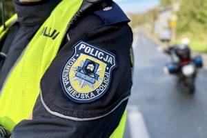 zdjęcie przedstawia policjanta zabezpieczającego trasę maratonu