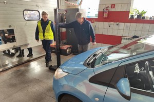 zdjęcie przedstawia policjantkę i diagnostę w trakcie sprawdzenia świateł pojazdu