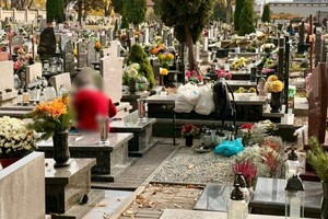 zdjęcie przedstawia torebkę damską leżącą bez opieki przy grobie