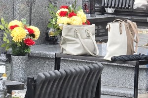 zdjęcie przedstawia torebkę damską leżącą bez opieki przy grobie