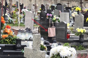 zdjęcie przedstawia torebkę damską leżącą bez opieki przy grobie