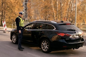 zdjęcie przedstawia policjantów w trakcie kontroli drogowej.