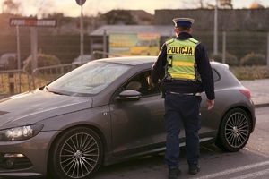 zdjęcie przedstawia policjantów w trakcie kontroli drogowej.