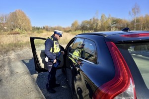zdjęcie przedstawia policjanta w trakcie kontroli prędkości