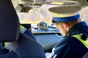 zdjęcie przedstawia policjanta w trakcie kontroli prędkości