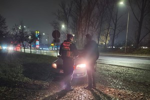 zdjęcie przedstawia policjanta w trakcie kontroli drogowej