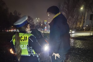 zdjęcie przedstawia policjanta w trakcie kontroli drogowej