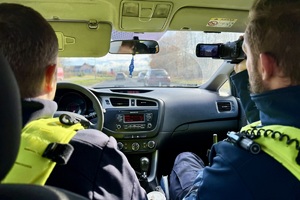zdjęcie przedstawia policjantów w trakcie kontroli ruchu drogowego