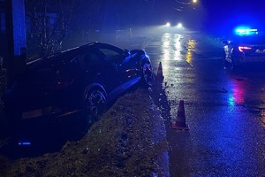 zdjęcie przedstawia samochód w rowie, obok stoi radiowóz.