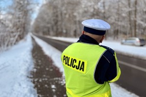 zdjęcie przedstawia policjanta wykonującego pomiar prędkości