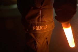 zdjęcie przedstawia policjanta w trakcie kontroli trzeźwości kierujących