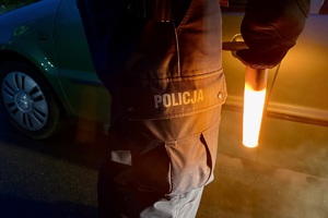 zdjęcie przedstawia policjanta w trakcie kontroli trzeźwości kierujących
