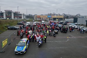 zdjęcie przedstawia policjantów zabezpieczających przejazd motocyklistów w strojach mikołajów