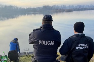 zdjęcie przedstawia policjanta kontrolującego miejsce sprzedaży ryb