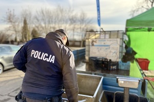 zdjęcie przedstawia policjanta kontrolującego miejsce sprzedaży ryb