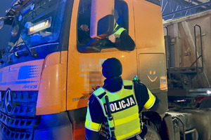 zdjęcie przedstawia policjanta w trakcie kontroli trzeźwości kierującego samochodem.