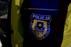 zdjęcie przedstawia policjanta w trakcie kontroli trzeźwości kierującego samochodem.