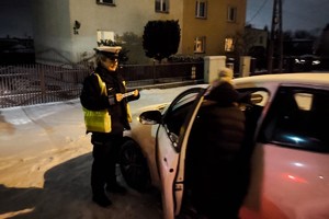 zdjęcie przedstawia policjantkę wręczającą elementy odblaskowe kobiecie