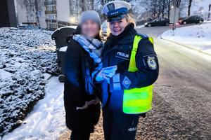 zdjęcie przedstawia policjantkę wręczającą elementy odblaskowe kobiecie
