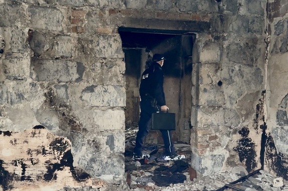 zdjęcie przedstawia policjanta kontrolującego pustostan