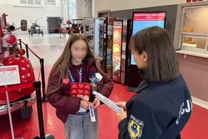 zdjęcie przedstawia policjantkę wręczającą odblaski wolontariuszowi