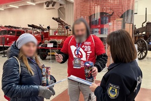 zdjęcie przedstawia policjantkę wręczającą odblaski wolontariuszowi