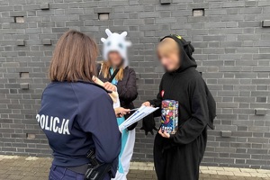 zdjęcie przedstawia policjantkę wręczającą odblaski wolontariuszowi