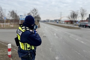 zdjęcie przedstawia policjanta w trakcie kontroli drogowej