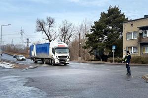 na zdjęciu policjant zatrzymuje do kontroli ciężarówkę