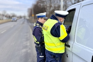 zdjęcie przedstawia policjantów kontrolujących pojazd ciężarowy