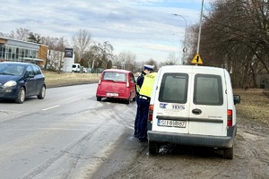 zdjęcie przedstawia policjantów kontrolujących pojazd ciężarowy