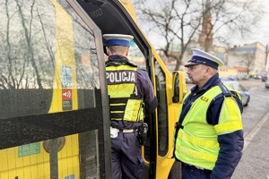 zdjęcie przedstawia policjantów kontrolujących pojazd ciężarowy